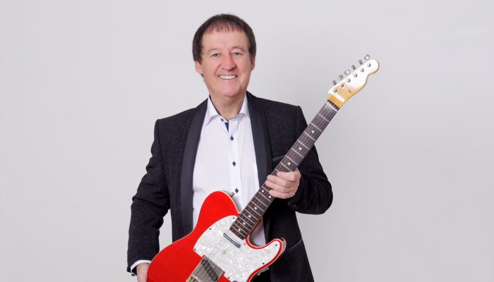 Declan Nerney holding a red guitar